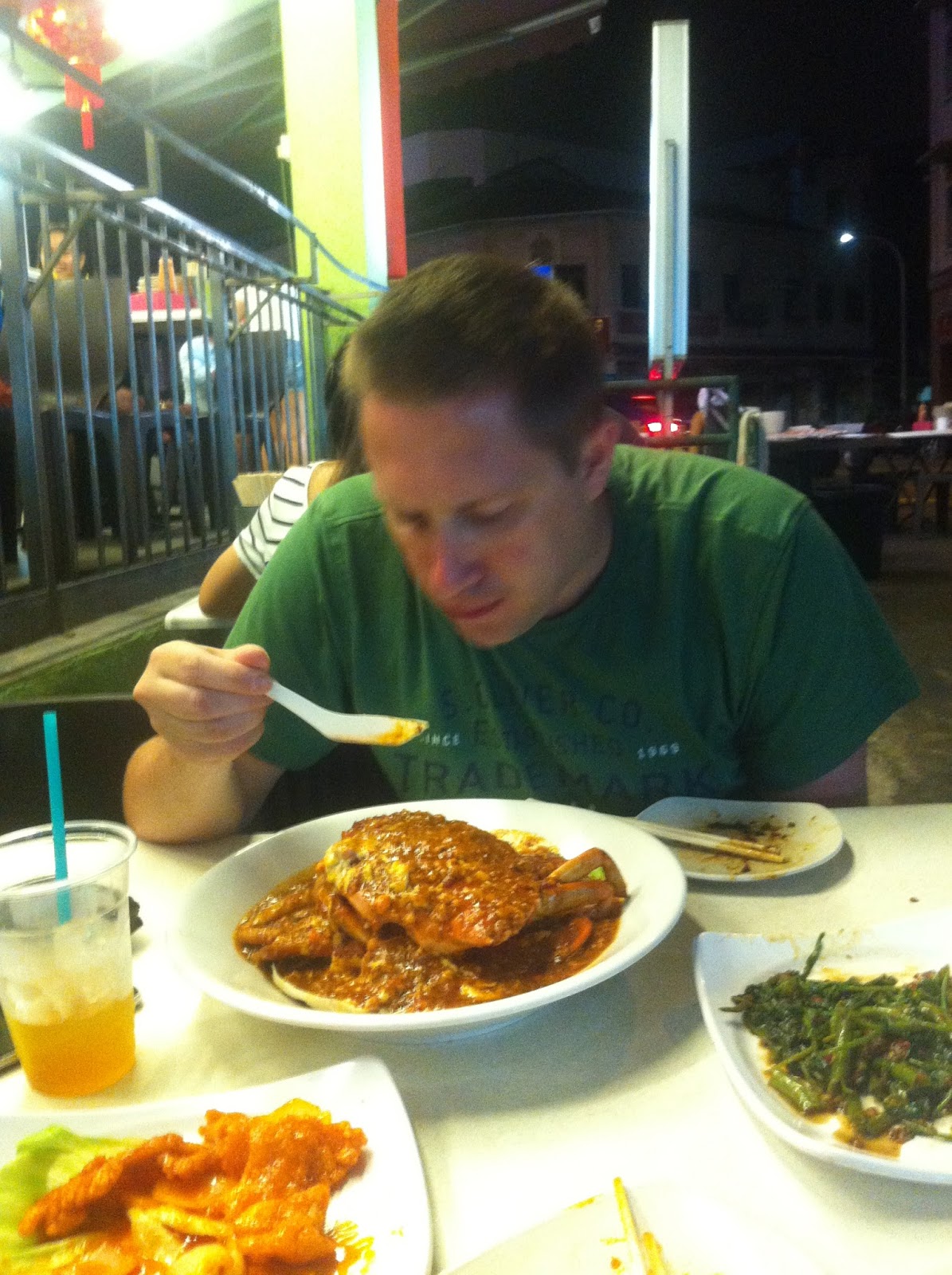 Eating chilli crab at a night seafood stall in Southeast Asia