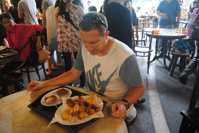Trying fried street snacks at a hawker market in Southeast Asia