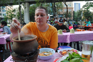 A clay pot of tom yum at a night street restaurant in Thailand